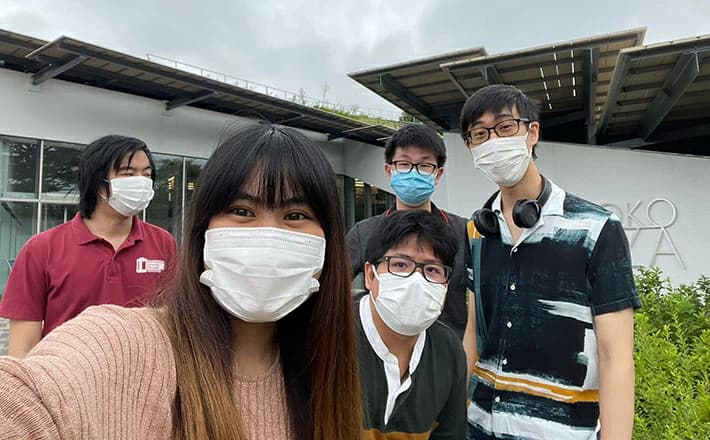 Ornida and the four other members of the Unsolved team standing outside a Tokyo Tech building, wearing masks