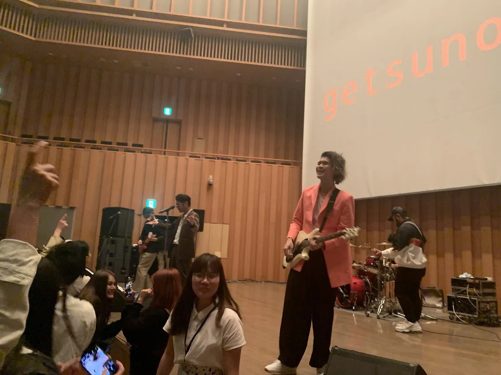 The band Getsunova performing on stage while the audience takes photos