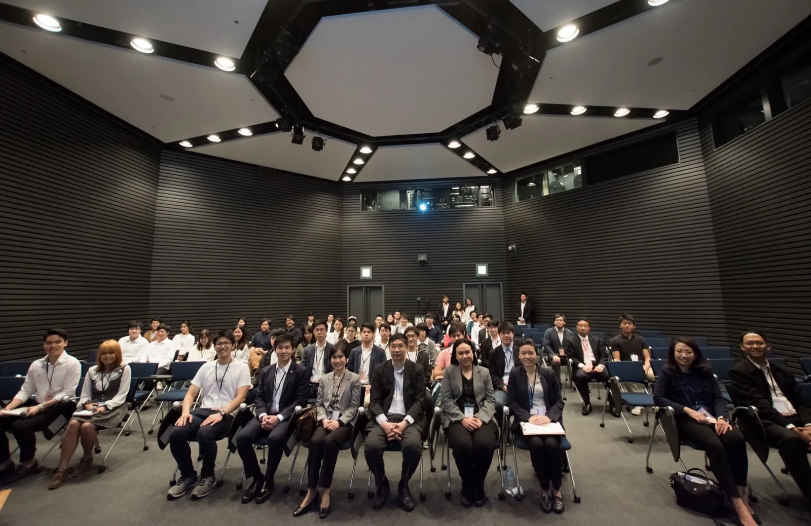 Group photo of Idea Day participants and judges seated in a hall